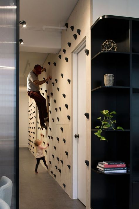 Upon entering this modern apartment, there's a plywood wall with rock climbing grips that lines the hallway. #RockclimbingWall #Rockclimbing #InteriorDesign Outdoor Themed Bedroom, Home Climbing Wall, Indoor Climbing Wall, Acnh Basement, Table Room, Plywood Walls, Rock Climbing Wall, Indoor Climbing, Apartment Renovation