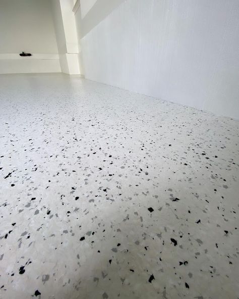 This customer in Charlotte, NC, chose a custom white flake blend featuring a 5% addition of black and light gray flakes to create a terrazo-looking appearance for their modern design custom home. White Epoxy Floors In Home, Light Grey Epoxy Floor, Matte White Epoxy Floor, Light Grey Epoxy Garage Floor, Solid Color Epoxy Floor, Epoxy Garage Floor Colors Flakes, Color Epoxy, Epoxy Floors, Garage Floors