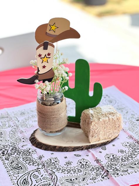 Used round wood a mason jar some tule and painted the cactus from the dollar tree and added the small bailes from the dolllar tree. The wood cut images came from hobbylobby. Mason Jar Western Centerpieces, Western Style Centerpieces, Cow Mason Jar Centerpieces, 1st Rodeo Centerpieces, First Rodeo Centerpiece, Cowboy Centerpiece Ideas, Western Table Decor, Cowboy Centerpieces, Cowboy Birthday Cakes