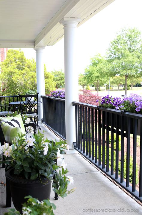 Flower Boxes Porch Railing, White Porch Posts Black Railing, Flower Boxes Front Porch, Porch Planter Boxes Railing, Planter Boxes Around Deck Railing, Window Boxes On Porch Railing, Porch Rail Flower Boxes, Porch Rail Planters, Flower Boxes On Porch Railing