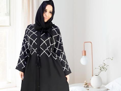 Experience the elegance and glamour of our black and silver diamond thread work zoom material open abaya. Designed for the fashion-forward Muslimah, this garment is perfect for any occasion, be it formal or casual. With its v-neckline design and regular sleeves, it offers a comfortable fit while exuding style. The added convenience of pockets on both sides provides ample storage space for your essentials. Complete with a hijab and belt, our abaya comes in a variety of sizes for the perfect fi... Open Abaya, Neckline Designs, Thread Work, Black And Silver, Silver Diamonds, Both Sides, Be Perfect, Storage Space, Fashion Forward