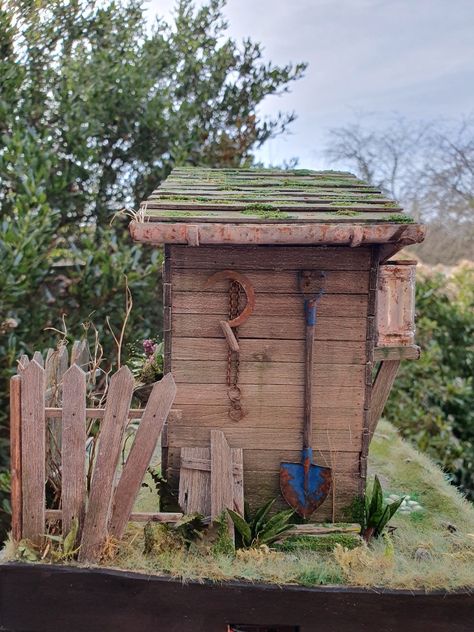 Outhouse toilet diorama back with old pieces of wood covered in moss, a sickle, a rusty chain and a worn spade. Old Outhouse, Outhouse Toilet, Rusty Chain, Wood Cover, Chain, Wood