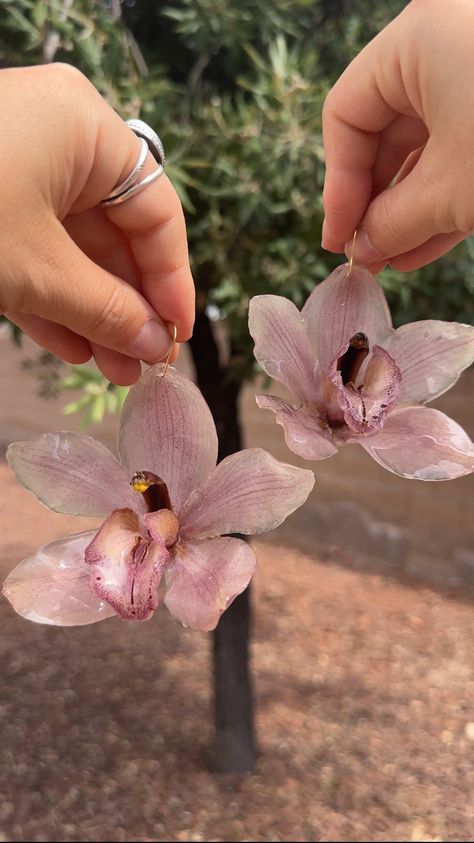 Preserved pink cymbidium orchids in resin on 18k gold filled earring hooks weight around 12g or two quarters. Pre order available once current inventory runs out. 4-5 week timeline for all pre orders! Thank you for your patience! Pink Cymbidium Orchids, Cymbidium Orchid, Orchid Earrings, Flower Resin Jewelry, Diy Jewlery, Cymbidium Orchids, Modernist Jewelry, Dope Jewelry, Ear Candy