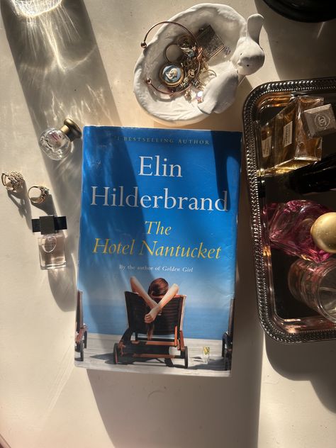 The book Hotel Nantucket next to a bowl of jewelry and perfume The Hotel Nantucket Book, The Hotel Nantucket Book Aesthetic, Hotel Nantucket Book, The Hotel Nantucket, Hotel Nantucket, Christmas Must Haves, Elin Hilderbrand Books, Nantucket Hotels, Elin Hilderbrand