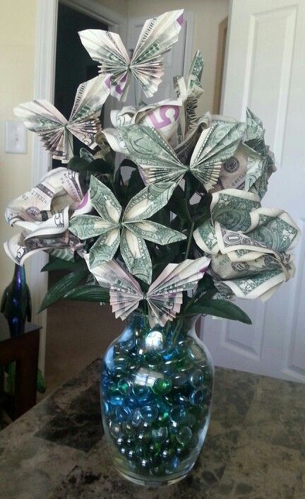 Money Origami Bouquet! Made with $137. Money roses(5 bills each), butterflies (2 bills each) and pinwheels(3 bills each) A fun way to give the gift of cash!  My sister loved her graduation gift!  Also great for mother's/father's day, birthdays or weddings! Follow Christina Waller for more great ideas! Folding Money Into Flowers, Mother’s Day Roses With Money, Cash Flowers Dollar Bills, Rose Money Origami, Money Tree Diy Cash Gifts, Money Roses, Bouquet Money, Flower Money, Origami Flower Bouquet