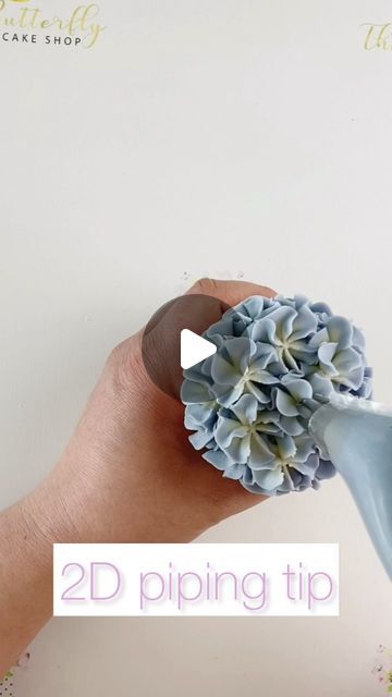 Kirsty on Instagram: "Here is how I pipe my lovely full hydrangeas using the Wilton 2D tip. Remember to keep that bag nice and tight! ♥️ #buttercreamdream #cakemasters #cupcakeartist #cupcakeinspo  #caketutorial #pipingtips #ediblebouquet #edibleroses #floristandflowers #caketutorials #cupcakeinspo #cupcakeartist #cupcakeart #cupcakelove #customcupcakes #americanbuttercream #flowercupcakes #bakingreels #reelife #cupcakereels #cakedecoratingreel #cakereel #cakereels #buttercreampetals #buttercreamflower #cakeflower #flowercakes #handmadeflowers #pipingreels #buttercreamdecorating #pipingnozzles #bouquetofcupcakes" Blue Hydrangea Cupcakes, Royal Icing Hydrangea Flowers, Piping Hydrangea Flowers, Cookie Piping Icing, Hydrangea Cupcakes Tutorial, Baby In Bloom Cupcake Ideas, Wilton 2d Tip, Cupcake Icing Tips, Wilton 2d