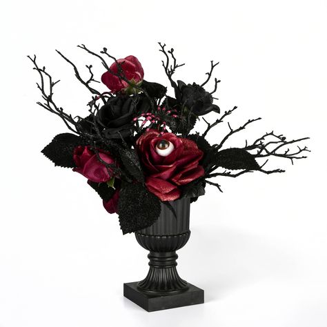 "Buy the 18'' Halloween Black Rose Plant at Michaels. com. Display this eerie Halloween décor on floor or tabletop in indoor or covered outdoor locations. This Halloween decoration features black rose blooms, some sprinkled with silver glitter, springing up from an ornate black urn base. It is trimmed with big black spiders and includes groups of glittering black leaves and spindly branch twigs for added creepiness. An eyeball emerges from one the roses to give this piece an even more frightenin Vampire Decor, Halloween Floral Arrangements, Gothic Wedding Theme, Company Halloween, Black Spiders, Halloween Themes Decorations, Halloween Kunst, Halloween Floral, Rose Plant