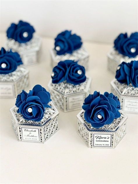 A wedding is a tapestry of love, woven together with unique details and personal touches. For couples seeking an unconventional yet timeless theme, the color blue offers a perfect palette to create an atmosphere of serenity, sophistication, and enduring love. Royal Blue And Silver Wedding Theme, Blue And Silver Wedding Theme, Royal Blue And Silver Quinceanera, Royal Blue Wedding Ideas, Royal Blue Wedding Favors, Royal Blue And Silver Wedding, Wedding Favors Boxes, Bride Shower Gifts, Royal Blue Wedding Theme