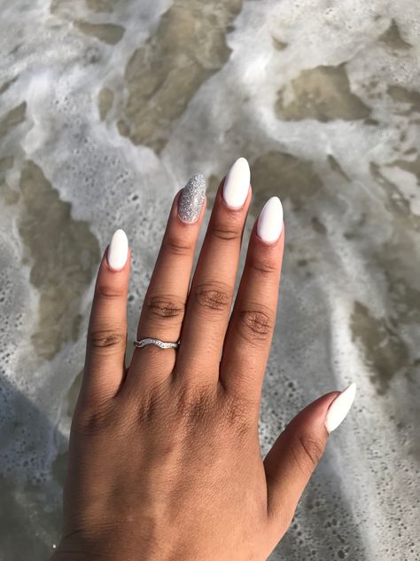 White almond nails with silver glitter accent nail #almondnails #snsnails #whitenails #glitternails Almond Nails Tan Skin, Almond Nails With Silver, Nails With Silver Glitter Accent, Silver Glitter Accent Nail, White Oval Nails, White Sparkle Nails, Nails With Silver Glitter, Nails With Silver, Oval Acrylic Nails