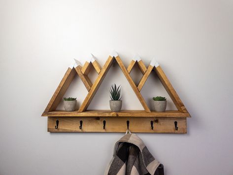 Introducing our stunning 5 Peak Mountain Shelf with coat hooks, a unique and eye-catching piece that will add a touch of natural beauty to any room. Measuring 27"L, 17" H, and 3.5" in depth, this hand-made shelf is made from the finest wood, sanded to a smooth finish and held together with ultra strong wood glue and finishing nails. This mountain shelf is the perfect addition to any home, office, or studio, providing both functional storage and a stunning visual display. With its pre-installed h Wood Mountain Shelf, Varathane Wood Stain, Keyhole Hangers, Mountain Shelf, Adventure Decor, Shelf With Hooks, Drywall Anchors, Hexagon Shelves, Regal Design