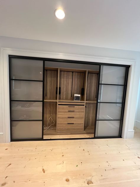 Warm wood finish and glass sliding doors make this reach-in closet stylish and functional.  #moderncloset#modernreachincloset#closetdesign#homeorganization#luxecloset#closetgoals Built In Closet Sliding Doors, Closet Design Layout Sliding Doors, Glass Closet Doors, Glass Closet, Glass Sliding Doors, Reach In Closet, Walk In Closet Design, Dining Room Remodel, Modern Closet