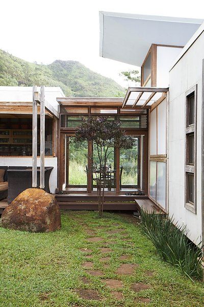 The building process was a collaborative one, with the Gambys and their architects engineering the house to meet building codes as the pieces were being installed. In the middle, a glass hallway containing the dining room connects to the kitchen. Photo 17 of 22 in Grateful Shed Asphalt Walkway, Glass Hallway, Residence Exterior, Building Process, Hawaii Homes, Building A Shed, House Extensions, Garden Room, Container House