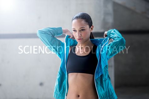 Young woman putting on hooded top after exercise. Pulling Hood Up Pose, Person Pulling Up Hood Reference, Taking Off Hoodie Reference, Functional Hooded Running Top, Breathable Hooded Sports Top, Hooded Dry-fit Workout Top, Hood Reference, After Exercise, Story Design