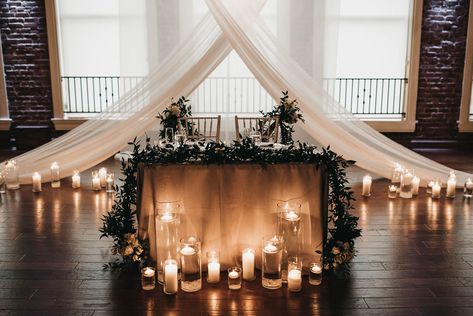 Sweetheart tables, or head tables, are always extra beautiful. Our wedding planner repurposed our italian ruscus garland from the aisle so that our sweetheart table would look full, intimate, and luxurious! Industrial Sweetheart Table, Sweat Heart Table Wedding Ideas, Candle Sweetheart Table, Black And White Sweetheart Table, Italian Ruscus Garland, Ruscus Garland, Rustic Sweetheart Table, Sweetheart Table Backdrop, Modern Draperies