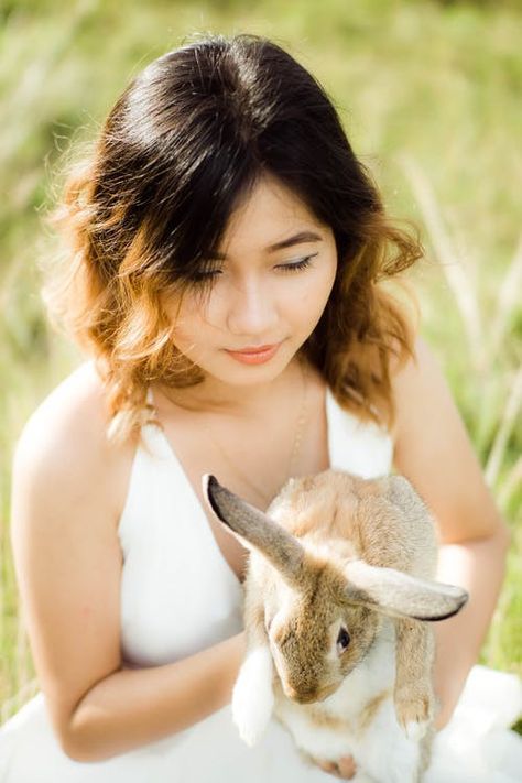 A woman in white top holding a rabbit😍 Person Holding Bunny Reference, Holding Bunny Pose, Person Holding Bunny, Holding Bunny, Rabbit Pose, Illustration Reference, Woman In White, Female Face, Bunny Rabbits