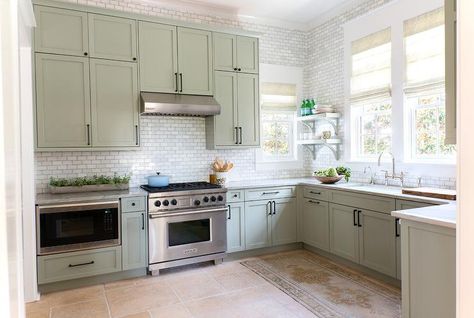 Gorgeous cottage kitchen boasts gray green shaker cabinets adorned with oil-rubbed bronze hardware paired with gray marble countertops and a white marble mini brick tile backsplash. Green Cabinets Black Hardware, Sage Kitchen, Kitchen Cabinet Trends, Green Apartment, Cottage Kitchens, Green Cabinets, Beach House Design, Kitchen Trends, Cottage Kitchen