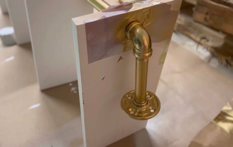 A gold-painted pipe attached to a DIY plant shelf. Diy Swivel Shelf, Diy Swivel Plant Shelf, Swivel Window Plant Shelf Diy, Rotating Plant Shelf Diy, Diy Window Sill Plant Shelf, Window Plant Shelves Diy, Window Sill Plant Shelf, Diy Window Sill, Diy Window Shelf