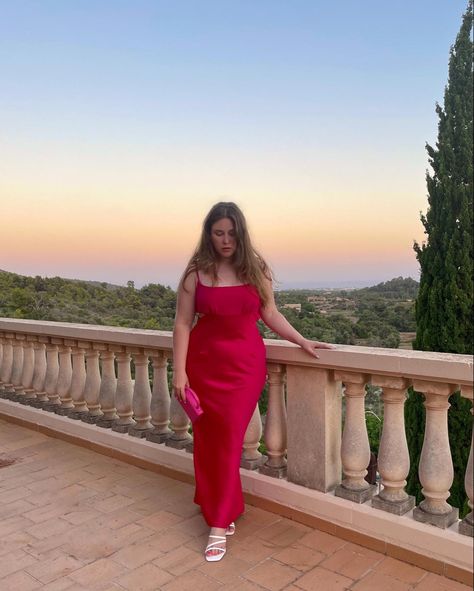 Long haired curvy girl standing on a balcony with a beautiful view of land and the see behind her. Beautiful yellow, rose and blue sunset. She wears a Pink bodycon dress with white high heel sandals and a matching pink bag in her right hand. Pink Bodycon Dress Outfit, Dress For Midsize, Midsize Dresses, Outfit Inspo Midsize, Midsize Summer Outfit, Bodycon Dress Outfit, Outfit Midsize, Curvy Summer Outfits, Midsize Summer