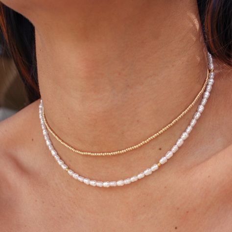 Get ready to fall in love with the Leia Necklace! This stunning piece features faux pearls and gold beads, delicately strung on a gold plated stainless steel chain. With its minimalist design and durable construction, the Leia Necklace is perfect for everyday wear or as a beautiful addition to your beach jewelry collection. • 18k PVD Gold Plated over Stainless Steel chain• Faux Pearls• Gold plated stainless steel bead• Length: 14.5" + 2" extender Fresh Pearl Necklace, Beads Craft Jewelry, Pearl Beach, Beads Craft, Beach Necklaces, Gold Bead Necklace, Craft Jewelry, Stacked Jewelry, Jewellery Designs