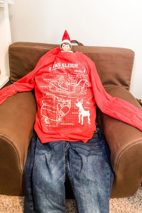 How funny is this elf on a shelf set up? Use your kids’ clothes, husband’s clothes, or your clothes to set up this silly elf on the shelf set up where he is wearing human clothes. This is just one of 50+ Elf on the Shelf ideas for home. There are tons of easy ideas, funny ideas, last minute ideas, and more. Plus, you’ll get a set of free Elf on the Shelf planning printables. This includes a blank elf on the shelf calendar, list of elf on the shelf ideas, printable elf on the shelf notes, a ... Elf On A Shelf Clothes Diy, Cute Elf On The Shelf Outfit Ideas, Elf On The Shelf Outfits, Elf On The Shelf Notes, Elf On The Shelf Calendar, Printable Elf On The Shelf, Target Outfits, Funny Ideas, Elf Antics