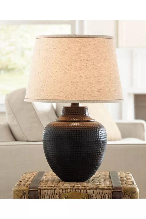 This lamp features a metal base with an eye-catching hammered texture in a warm bronze finish, creating a rustic and inviting ambiance. The lamp is topped with a beige linen drum shade, elegantly trimmed with brown accents on both the top and bottom, adding a refined touch to the overall design. Farmhouse Table Lamp, Brown Leather Couch, Farmhouse Table Lamps, Rustic Farmhouse Table, Rustic Table Lamps, Bedside Night Stands, Leather Couch, Rustic Living Room, Farmhouse Table