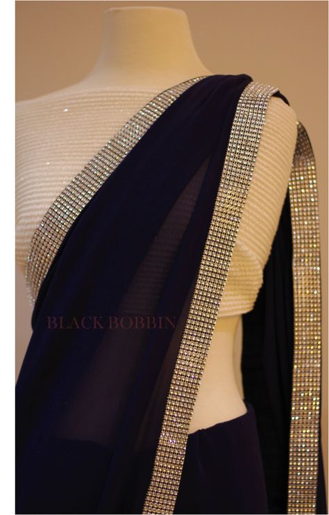 Black Bobbin - Featuring a rich navy blue Georgette saree with a silver sparkling border. It comes with an un-stitched white sequin blouse piece as per the photo. This stunning saree is perfect for a special occasion, day or night event. Contact us: blackbobbinmelbourne@gmail.com Black Saree Sequence, Navy Blue Saree With White Blouse, Silver Blouse Designs For Saree, Black Saree With White Blouse, Navy Blue Saree With Silver Blouse, Black And Silver Saree, Silver Blouse Black Saree, Party Black Sequined Saree, Black Shimmer Saree