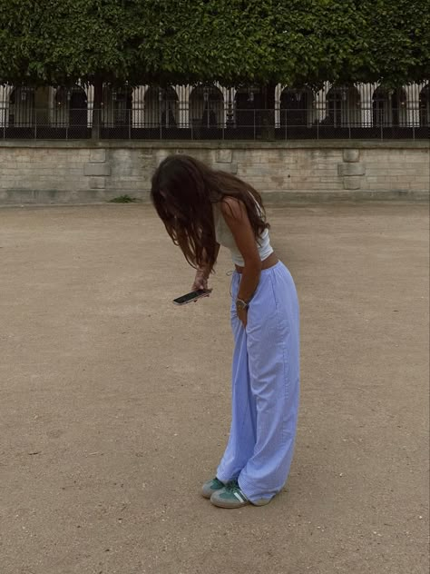 Ig pose for insta, jardin des tuilerie, paris street style, casual outfits idea, spring outfit inspo, zara viral pant, white top, green adidas samba, aesthetic pose, aesthetic outfit Green Shoe Outfits Women, Pyjama Pants Outfit Street Styles, Green Adidas Samba Outfit, Green Sambas Outfit, Adidas Samba Outfit Women Street Styles, Green Shoe Outfits, Linen Pants Outfit Casual, Green Adidas Outfit, Green Samba Outfit