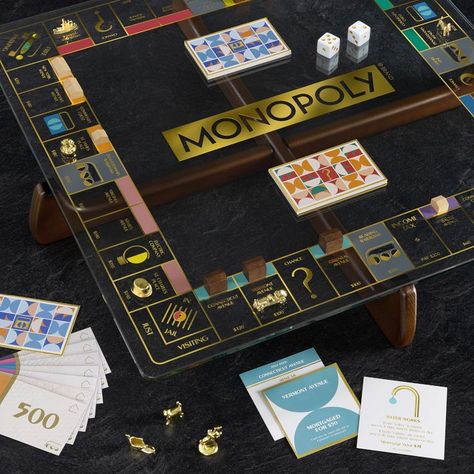 The Prisma Edition of Monopoly is a little hip, a little retro and all wow. The glass gameboard rests on a sleek, solid wood base with a gorgeous walnut finish. With touches of gold everywhere, this game is almost too fancy to put away. Great for gifting, its colorful, custom components and convenient storage box make it super unique. Made of wood, felt, tempered glass, paper, zinc die cast and acrylic. Includes a tempered-glass game board with gold foil, solid wood base with walnut stain, foil- Monopoly Game Board, Custom Monopoly, Monopoly Board Game, Georg Jensen Jewelry, Board Game Box, Monopoly Money, Monopoly Board, Mirrored Picture Frames, Monopoly Game