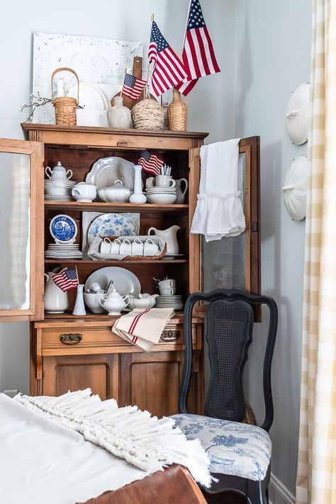 Add patriotic style and Americana charm for the summer by tucking a few flags in with the vintage dishes in your hutch or cabinet for an easy and striking arrangement! DIYBeautify.com #summer #patriotic #flags #decorating Patriotic Decor Ideas, Decorating With Flags, Blue Cloth Napkins, Cupboard Decor, Hutch Decor, Blue Mason Jars, Off White Paints, Favorite Paint Colors, Blue Paint Colors