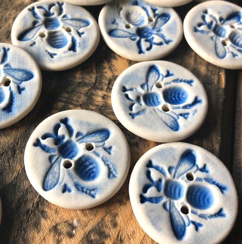 These lovely Delft hand made porcelain buttons feature an embossed blue bee. They have a smooth feel and a matte appearance.  Each is individually made and unique but I will make sure your set contains buttons that are similar and work well together.  The  porcelain used to form these buttons has been fired in my kiln  to the stage of stoneware and the buttons are not affected by water or detergent. The Delft Bee  buttons are available as single buttons or in sets of 4, 5, or 6 buttons.  Size:  approx.    1  1/8inch Hand Painted Buttons, Ceramic Buttons Handmade, Pottery Buttons, Porcelain Buttons, Polymer Clay Buttons, Clay Buttons, Blue White Ceramic, Unique Buttons, Ceramic Buttons