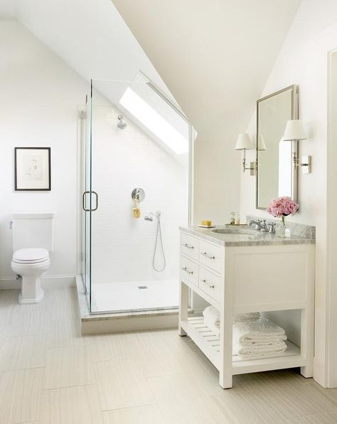 An en suite bathroom is filled with a white vanity with shelf topped with carrera marble, Restoration Hardware Hutton Single Washstand, placed under a polished nickel mirror illuminated by polished nickel sconces. Sloped Ceiling Bathroom, Low Ceiling Attic, Attic Shower, Attic Bathroom Ideas, Slanted Ceiling, Transitional Home Decor, Attic Bathroom, Bad Inspiration, Transitional Bathroom