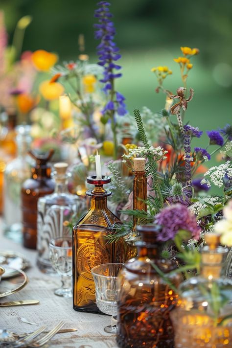 Elevate your wedding decor with a unique touch of the past. These vintage perfume bottles turned vases are filled with an array of herbs and wildflowers, perfect for a bohemian-themed celebration. 🌿🌼💐 A touch of nostalgia meets natural beauty for your special day. #WeddingInspiration #BohoWedding #CenterpieceIdeas #VintageDecor #FloralDesign #DIYWedding #EventStyling #WeddingFlowers Flowers In Whiskey Bottles, Glass Bottles With Flowers, Antique Glass Wedding, Wildflower Wedding Centerpiece Boho, Wedding Herbs Decoration, Wedding Wildflowers Decoration, Vintage Glass Wedding Decor, Diy Wildflower Wedding Decor, Thrifted Wedding Favors