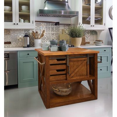 Utility and style go hand-in-hand with this kitchen island. It places an industrial twist on its farmhouse styling. Sleek yet simple, it features a solid butcher block top with a fold-out leaf for seating, a barn-type sliding door, and towel and spice racks on opposite sides. Solid mahogany and mango wood make up the top and base of this piece, respectively, with touches of metal hardware throughout to complete the look. Made in Indonesia. | Gracie Oaks Jaren Kitchen Island Brown 37.0 x 43.5 x 3 Vintage Kitchen Islands, Square Wood Kitchen Island, But Her Block Island, Unique Kitchen Island Ideas, Farmstead Kitchen, Butcher Block Kitchen Island, Farmhouse Styling, Freestanding Kitchen Island, Hutch Makeover