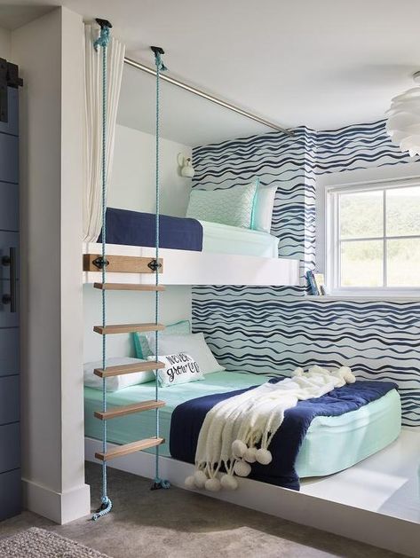 Mint green and blue bedding accented with a whtie pom pom throw blanket accents a white platform bed fixed beneath a white loft bed with matching bedding. Wavy Wallpaper, Aqua Bedroom, Cool Boys Bedroom Ideas, Small Beach Cottage, Teen Boy Bedroom Decor, Cool Bedrooms For Boys, Beach House Tour, Small Beach Houses, Condo Renovation