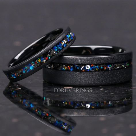 ►Material: Tungsten Carbide, Meteorite, and Opal ►Color: Black ►Comfort Fit ►His Band Width: 8mm ►Her Band Width: 4mm ►Fit is true to size for Her band (4mm). ►Fit is true to size for His Band (8mm). ►This hand-crafted tungsten ring features a stunning inlay of galaxy opal and meteorite flakes. The meteorite flakes are sourced from genuine Gibeon meteorite. The opal showcases a dazzling array of iridescent colors in sunlight. A beautiful alternative for a wedding band, this ring will stand out a Galaxy Wedding Dress, Gay Engagement Rings, Meteorite Rings, Black Titanium Ring, Galaxy Wedding, Gibeon Meteorite, Stunning Diamond Rings, Couples Ring, Matching Wedding Rings