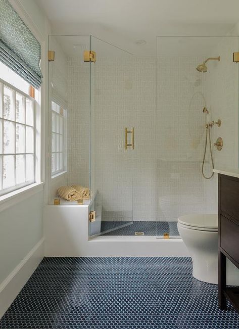 Navy penny floor tiles lead to a walk-in frameless glass shower accented with a brass handle. Gömda Rum, Penny Tiles Bathroom, Blue Bathroom Tile, Penny Tile, Shower Floor Tile, Floor Bathroom, Transitional Bathroom, Master Bath Remodel, Boys Bathroom