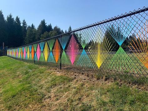 I added two more panels today because we all need a little more joy, color, and care. . . . #yarnbombing #geometry #chainlinkfence… | Instagram Yarn Fence Art, School Fence Decorations, Fence Weaving, Art Deco Garden, Outdoor Learning Spaces, Garden Decor Projects, Fence Art, School Garden, Usa Art