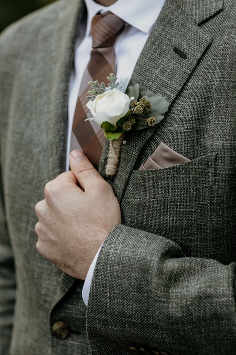 Brown plaid tie and silk pocket square with forest green tweed suit jacket. Artificial silk boutonniere with greenery. Ideas for groom attire and wedding suit inspiration for an autumn lake wedding in Waskesiu Lake, Prince Albert National Park, Saskatchewan, Canada. Intimate lakeside wedding with vintage rustic decor and details at Waskesiu Community Hall by Saskatoon wedding photographer Copperblue Photography and Design. #saskatoon #yxe #yxewedding #saskatchewan #waskesiu Green Tweed Wedding Suit Groom, Green Suit Brown Tie, Green And Brown Groom Suit, Cottagecore Wedding Groom, Tweed Groomsmen Attire, Cottagecore Groom Outfit, Green Tweed Suit Wedding, Autumn Wedding Suit, Forest Wedding Groom Attire