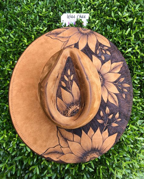 Blackout sunflowers *Vegan Suede Custom Burned Hat Personalization is free (name, short quote, date, small butterfly, etc.) Adjustable to fit large heads down to children size.   All hats come with a band and feather.  Priority Shipping with $100 Insurance. Please allow 2-3 weeks for delivery. These are handmade and in high demand.  If you need it sooner, please message me and I will try to accommodate you. Sunflower Cowboy Hat, Sunflower Burned Hat, Wood Burn Hat, Burned Ball Cap, Burnt Hat Design Ideas, Burnt Hat Design, Hat Burning Ideas, Diy Leather Hat, Burn Hats