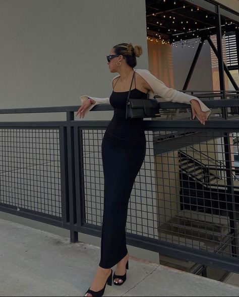 A girl is leaning against a railing with a long black, skin tight dress on. She’s  wearing black heels, a beige shrug, and a little black purse. Body Con Maxi Dress Outfit, Brunch Date Outfit Summer, Heels Baddie, Long Bodycon Dress Outfit, Black Bodycon Dress Outfit, Long Black Dress Outfit, Long Black Bodycon Dress, Tight Maxi Dress, Black Maxi Dress Outfit