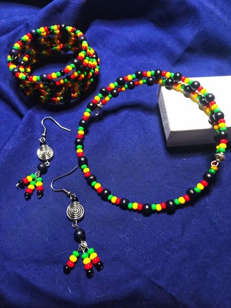 "Beautiful Set of Earrings, Choker Style Necklace and Bracelet in Stainless Steel Memory Wire in brilliant red, yellow, green and black in the Rasta theme. Each item is handcrafted carefully to follow colors in order and make the most out of these stunning pieces. All three pieces are made with Opaque Czech Glass and Wood and stainless steel memory wire (Choker/Bracelet) Earrings are stainless steel ear wire that are hypoallergenic, lead and nickel free.  Measure: 2\" With drop: 2.5\" adorned wi African Jewelry Diy, Jamaican Jewelry, Rasta Jewelry, Rasta Bracelet, Jamaican Fashion, Jamaican Party, African Necklaces, Gold Feather Earrings, Wire Choker