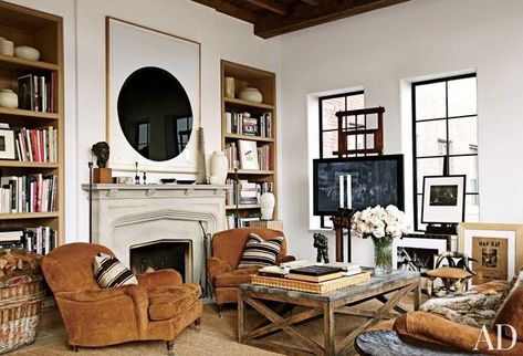 A large-scale work on paper by Richard Serra is given pride of place in the living area of a Manhattan apartment, where an LG flat-screen television is mounted on an artist's easel. A pair of Ralph Lauren Home club chairs and a vintage horn stool are grouped with a cocktail table by Lucca Antiques | archdigest.com Tv Room Design, New York City Apartment, New York Apartment, Rustic Living, City Apartment, Rustic Living Room, A Living Room, Ralph Lauren Home, Tv Room