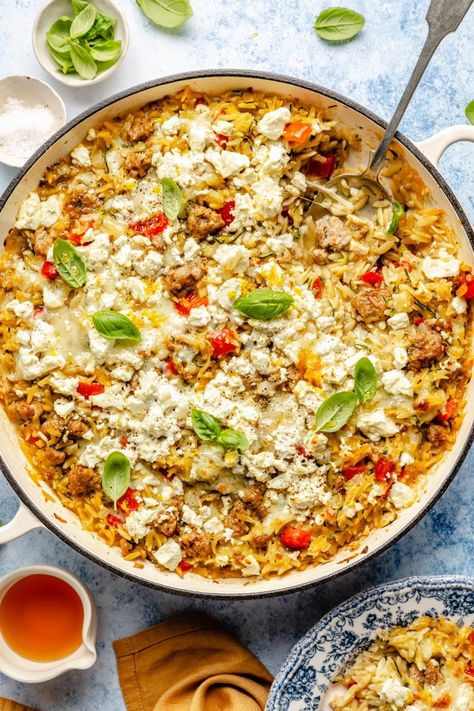 Comforting zucchini and sausage baked orzo packed with a rainbow of veggies and plenty of melty cheese. This one pan sausage baked orzo recipe is easy to make and customize, and is made extra delicious with a drizzle of hot honey. The perfect nourishing and cozy weeknight meal! Healthy Orzo Recipes Dinners, Zucchini And Sausage, All Carb Diet, Honey Feta, Zucchini Sausage, One Pan Sausage, Baked Orzo, Gluten Free Orzo, Pan Sausage