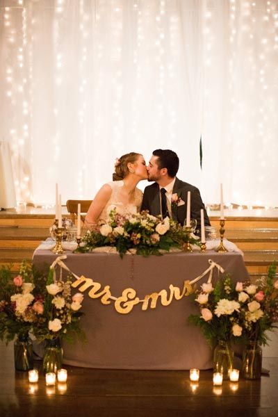 Set a romantic sweetheart table with beautiful flower arrangements and a twinkling backdrop. Wedding Couple Table, Reception Head Table, Winter Barn Weddings, Bride Groom Table, Light Backdrop, Girls Fun, Newly Married Couple, Wedding Table Decorations, Newly Married