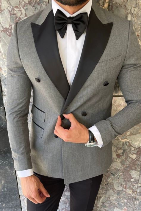 This is a grey and black tuxedo with a peak lapel and exaggerated bow-tie style. The perfect classy indian wedding outfit that will be a show stopper. If you want this custom-made for you, book an appointment at our Long Island showroom. Luxury Gray Tuxedo For Business, Grey And Black Tuxedo Wedding, Grey And Black Tuxedo, Luxury Gray Tuxedo In Suiting Fabric, Grey Tuxedo Men, Tuxedo Style Bow Tie For Black-tie Events, Grey Tuxedo Wedding, Groomsmen Attire Grey, Luxury Gray Three-piece Suit With Notch Lapel