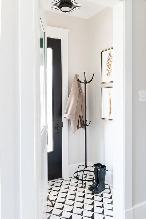 Vestibule with wrought iron coat rack, black and white geometric floor tiles and gold leaf frames illuminated by an oil rubbed bronze sunburst flush mount. Wainscoting Paint Ideas, White Tile Floors, Entryway Tile, Black And White Tile, Entry Tile, Kate Marker Interiors, Entryway Flooring, Narrow Hallway Ideas, Geometric Floor