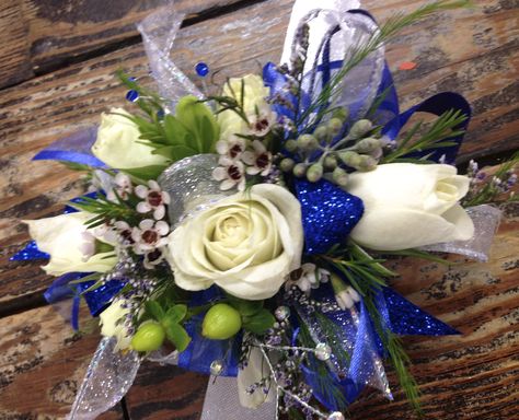 Glittery royal blue ribbon mixed with iridescent ribbon, white spray roses, wax flowers and a little bling! Mounted on a sliver slap band to fit any size wrist! Homecoming Bouquets, Hoco Corsage, Prom Corsage Blue, Gold Corsage, Ribbon Corsage, Prom Flowers Corsage, Blue Corsage, Prom Tux, Homecoming Flowers