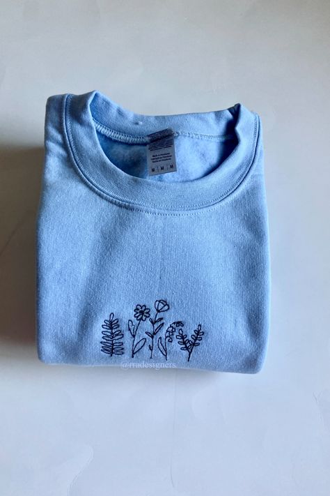 Collection of wildflowers embroidered on either a dark green, light blue or white sweatshirt. Super soft and comfortable pullover made to order! Functions as fashionable outerwear or comfy loungewear. Blue Sweater Embroidery, Small Embroidery Ideas Hoodie, Sweatshirt Embroidery Ideas Men, Blue Shirt Embroidery, Embroidered Clothes Sweatshirts & Hoodies, Hand Embroidered Crewneck, Embroidered Crewneck Diy, Cute Embroidered Sweatshirt, Embroidery Sweatshirt Diy