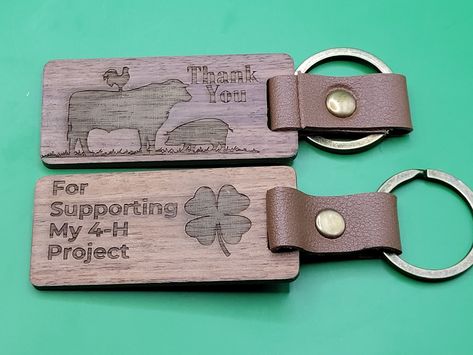 "Thank You For Supporting My 4-H Project Custom Engraved Wood Keychain This listing is for a single keychain. The photo represents both sides.  Made of 100% natural black walnut wood, leather and metal rings, these keychains are engraved with a clover and say, \"Thank You\" and a Livestock Graphic on one side and \"For Supporting My 4-H Project \" on the other.  These custom engraved keychains are great thank you gifts for 4-H Leaders, gifts for buyers, Project Leader gifts, or for any 4-H Suppo Ffa Thank You Gifts, 4h Gifts For Buyers, 4h Thank You Buyer Gifts, 4h Market Animal Buyer Gifts, 4h Buyer Thank You Signs, Thank You Cards For 4h Buyers, 4h Buyers Gift Ideas, 4-h Buyers Thank You Gifts, Leader Gifts