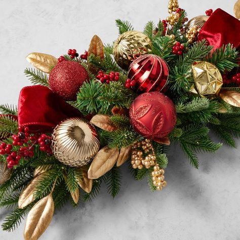 Celebrate the beauty of the holiday season with our 'Twas the Night collection featuring festive pieces in a coordinating color palette of red, gold, cream-white and green. A showy display for the dining table or entryway console, this centerpiece is resplendent with gleaming ornaments and velvet ribbon nestled amongst preserved and faux foliage. Hand-assembled of faux pine needles, berries, painted plastic and polyester; natural twig and wire base. Pre-strung with 70 warm white lights. Battery Red And Gold Christmas Centerpiece, Christmas Entry Table Decor, Christmas Centerpieces For Table, Gold And Red Christmas, Elegant Christmas Centerpieces, Christmas Arrangements Centerpieces, Christmas Floral Designs, Holiday Floral Arrangements, Christmas Entry